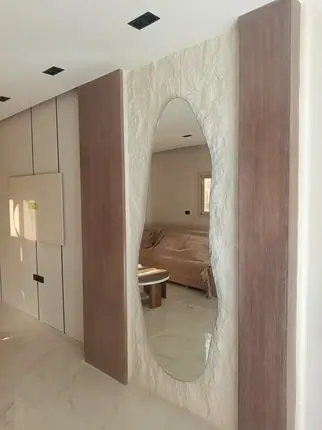 مراية ديكور بشكل حر على حائط حجر — من أعمال ميرور في دمياط